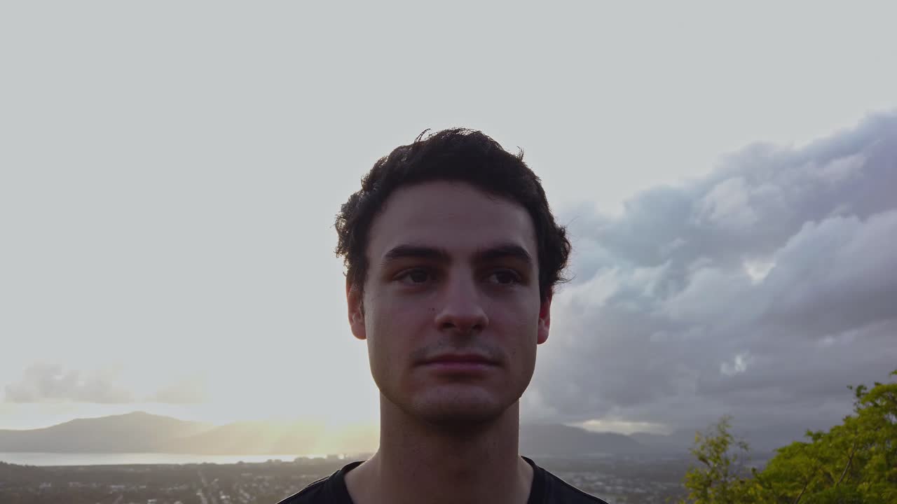un hombre mirando fijamente al desierto con la espalda hacia la brillante luz del sol y las nubes - cerca de pan - cámara lenta