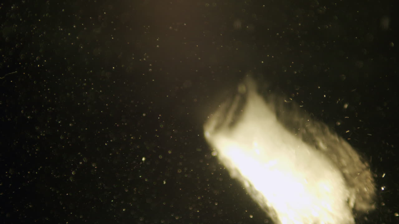 Ice cube falling in water in slow motion.