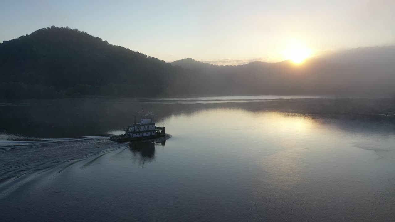 견인 보트 와 함께 강 위 의 해가 뜨는 것