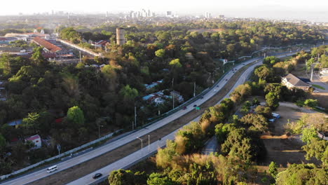 aerial view of winding highway cutting through trees and a small village