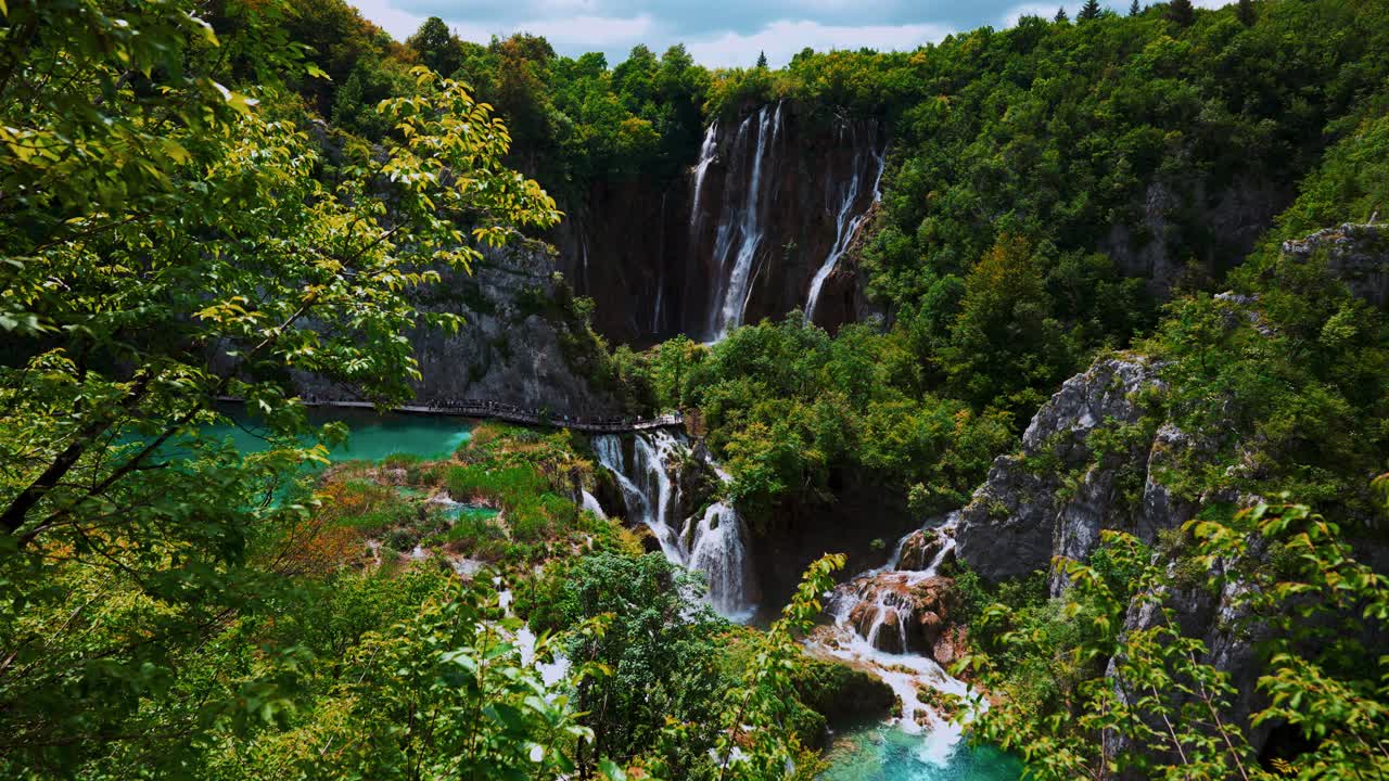 Waterfalls surrounded by green vegetation and cliffs in Plitvice Lakes National Park, Croatia