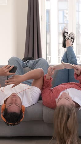 young couple relaxing and spending time together while laying on the couch at home.