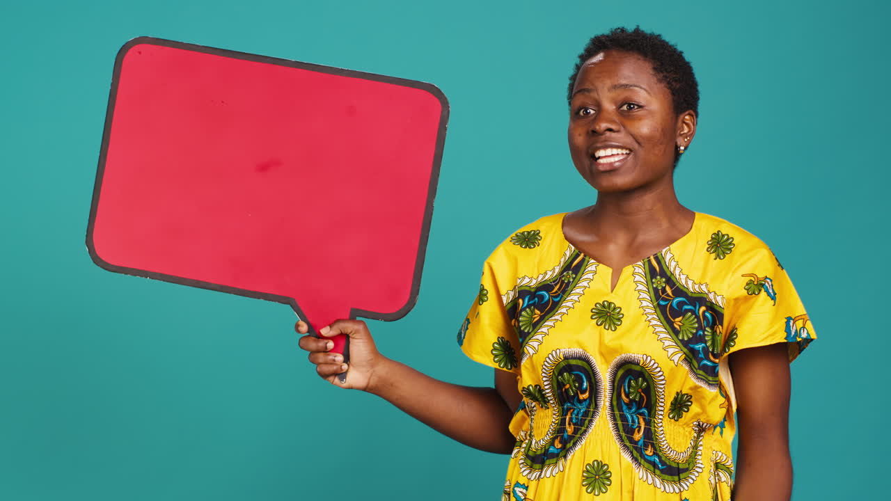 Smiling person showing a red isolated speech bubble in studio
