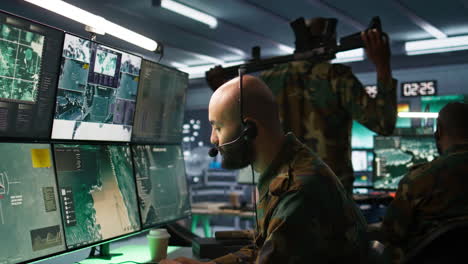 cerca del despachador que trabaja en la sala de guerra operando tecnología de vigilancia