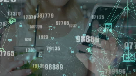 animación de procesamiento de datos e iconos de medios sobre mujer caucásica con bebida usando teléfono inteligente