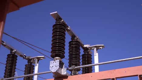 close-up view of high voltage electrical insulators and conductors at a power station, essential components of electrical grids