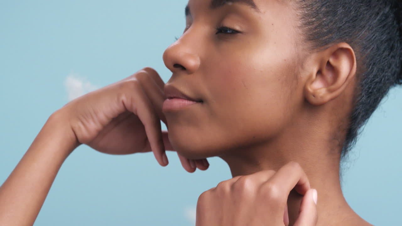 mujer africana tocando su suave piel con plumas