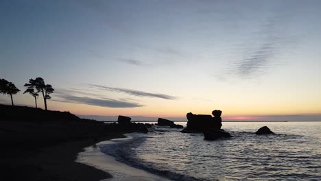 Beautiful-vibrant-high-contrast-sunset-low-altitude-flyover-over-the-Karosta-war-port-concrete-coast-fortification-ruins-at-Baltic-sea-at-Liepaja,-wide-angle-establishing-drone-shot-moving-forward