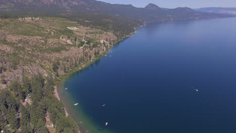 a scrubby hill leads steeply down to the cool lake on a hot summer day