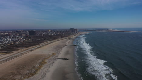 a drone view over an empty beach on a beautiful day with a few clouds