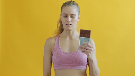 woman hesitating about eating chocolate bar