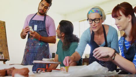 Drawing-teacher-assisting-artist-in-pottery-4k