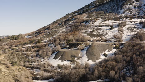 vuelo aéreo lento más allá de las montañas tintic del este y las entradas abandonadas de la antigua mina cerca de eureka, utah