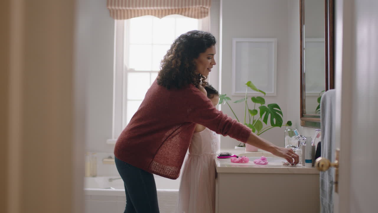 happy mother brushing daughters hair in bathroom cute little girl getting ready in morning loving mom enjoying parenthood caring for child