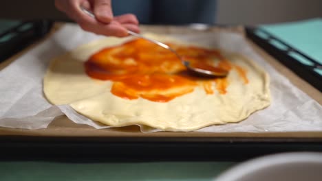 Frau-Verteilt-Tomaten-Auf-Pizzateig-Und-Bildet-Mit-Einem-Löffel-Kreise