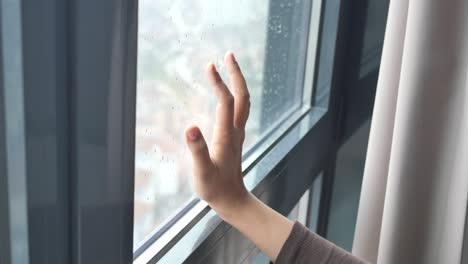 hand on a rainy window