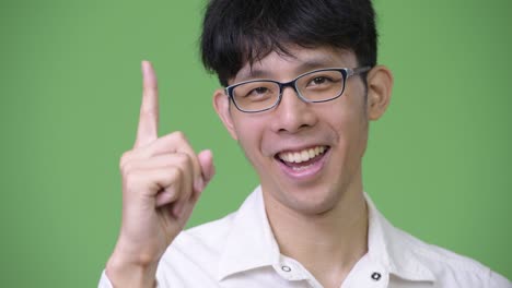 young asian businessman smiling while pointing up