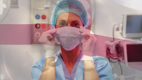 animation of flag of england waving over female surgeon in operating theatre