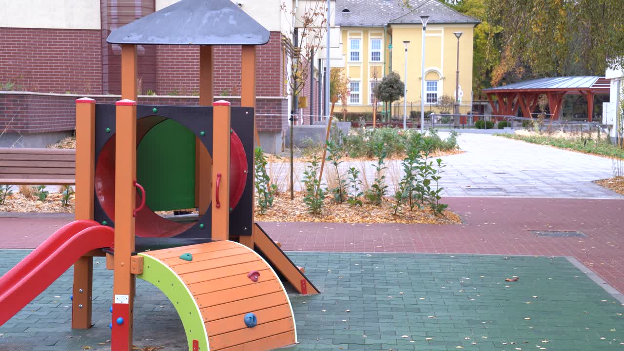 Parque infantil colorido vazio em um parque urbano durante o outono.