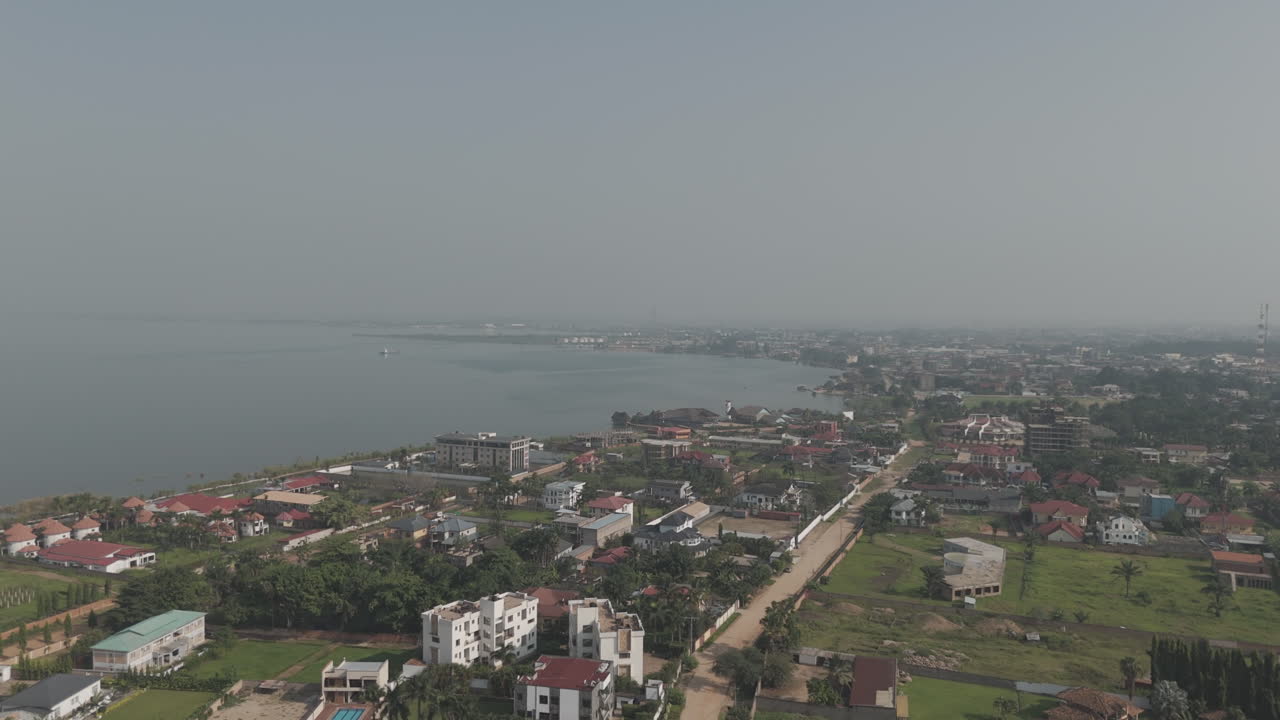 Drone shot above Bujumbura Burundi Africa looking over the houses and lake Tanganyika with mist and pollution in the air LOG