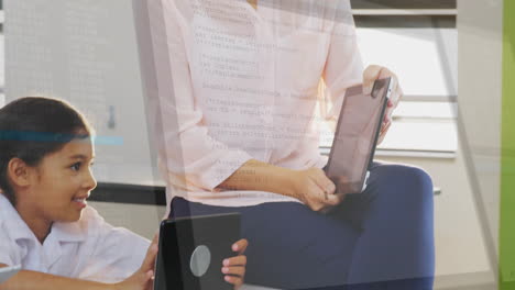 mother guiding daughter using tablets displaying code overlay for technology learning