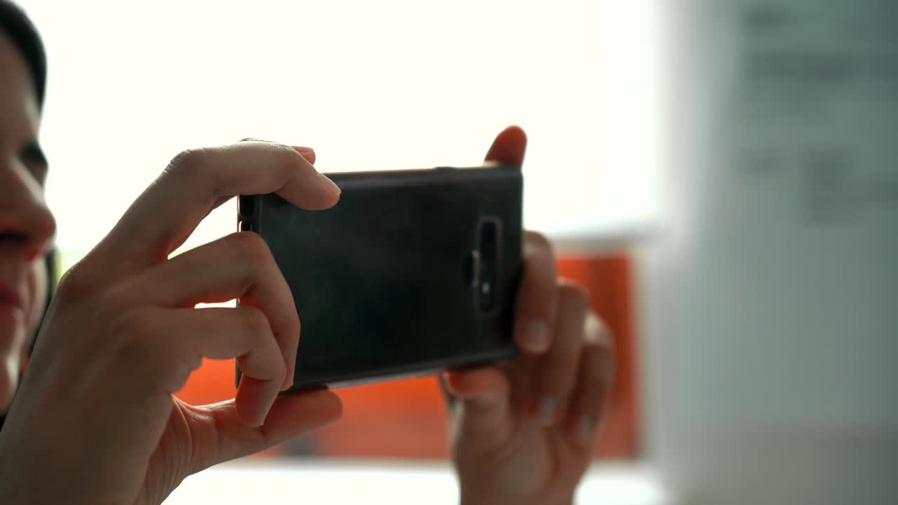 mujer viendo un video o contenido de redes sociales en un teléfono inteligente - aislada en las manos sosteniendo el teléfono