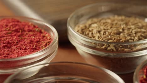 spices in glass bowls close-up. middle eastern and arabian culture. seasoning and flavors. pepper, coriander, vanilla, turmeric, paprika, cumin. different kinds of dry herbs for cooking.