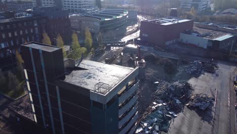 demolished multi storey car park concrete construction debris in town regeneration aerial view demolition close orbit left