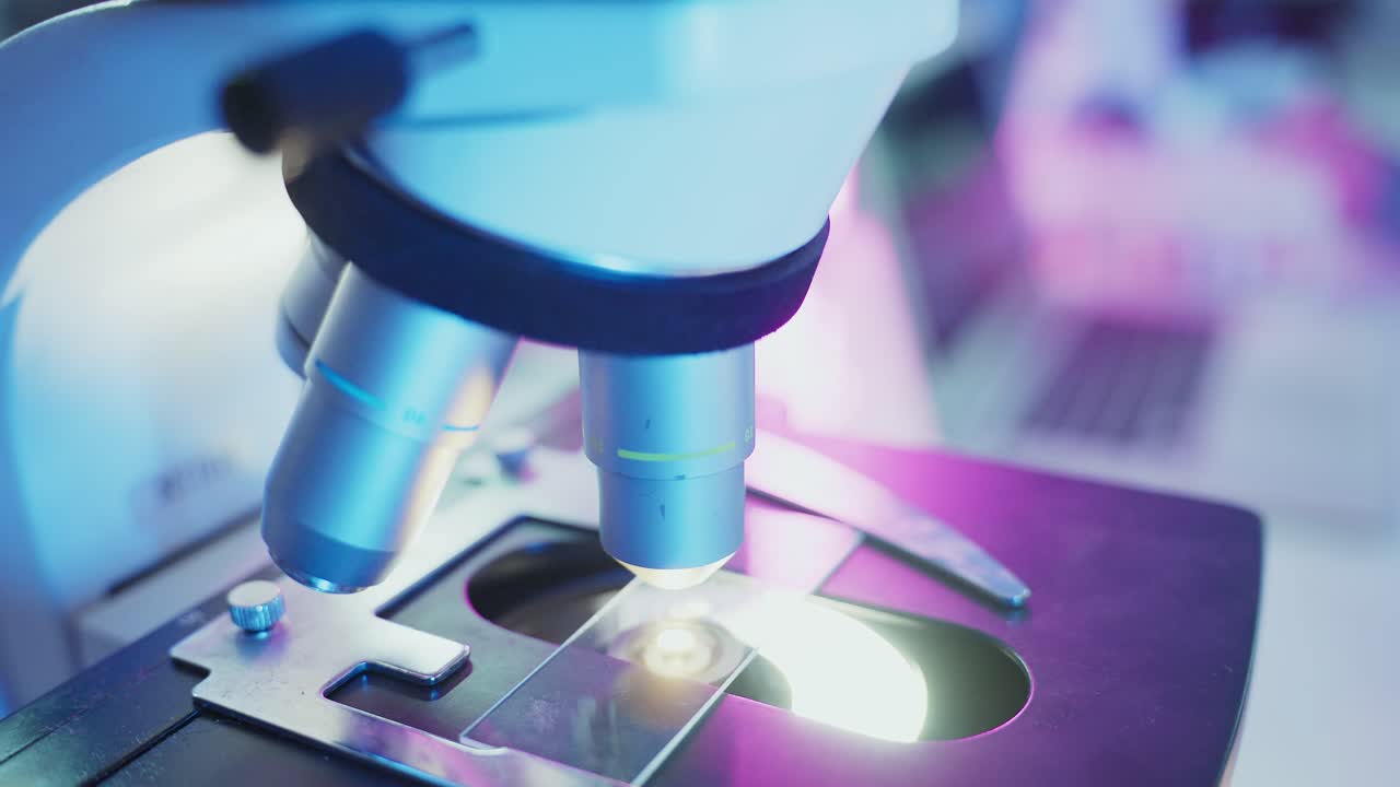 Scientist Adjusting Microscope Objective Lenses in a Laboratory