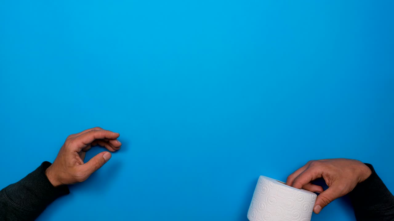 las manos se arrojan un rollo de papel higiénico