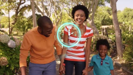 Neon-blue-digital-clock-ticking-against-african-american-family-holding-hands-smiling-in-the-park