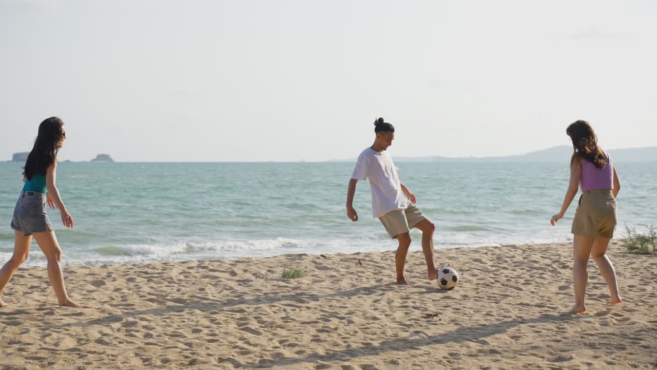친구 들 이 해변 에서 축구 를 하고 있다