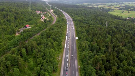 Two-lane-highway-congested-on-one-side-and-nice-traffic-flow-on-the-other-side-with-overpass-and-power-lines-in-a-European-country