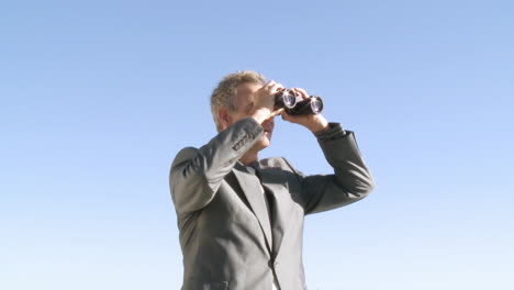 businessman watching through a binoculas