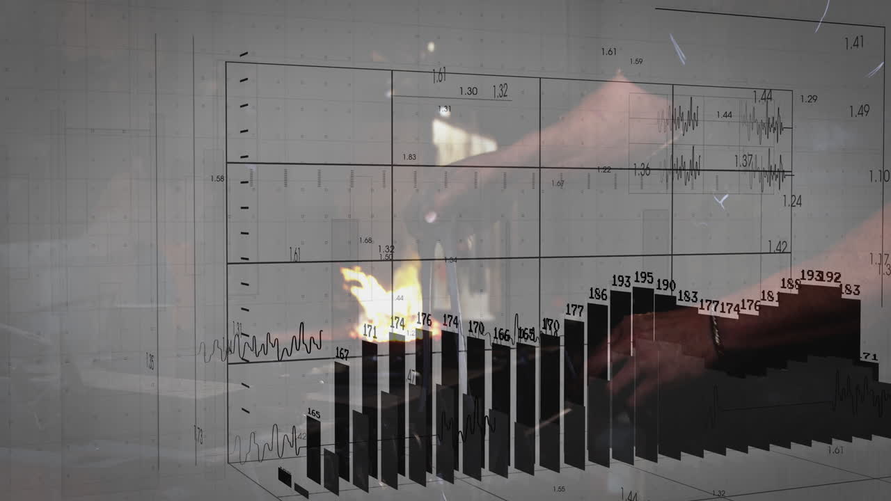 In workshop, person working with machinery while viewing bar chart and line graph