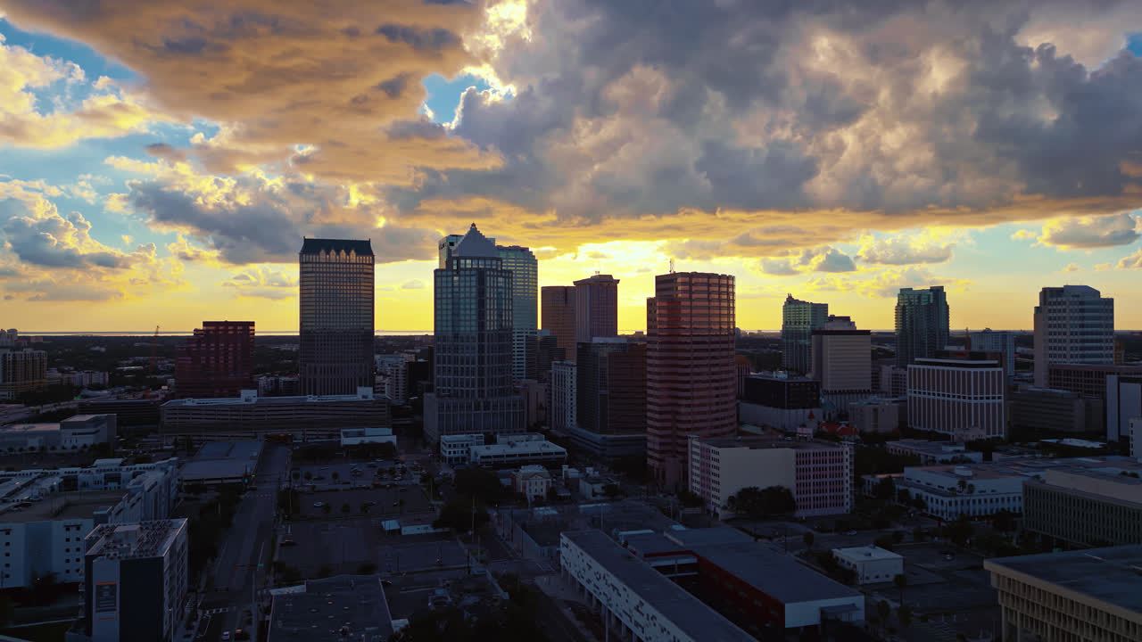 Sunset at dusk in downtown Tampa with massive dramatic clouds of yellow and blue in the sky with soft warm light all around