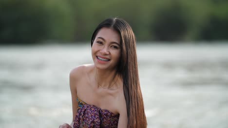 woman smiling outdoors near water