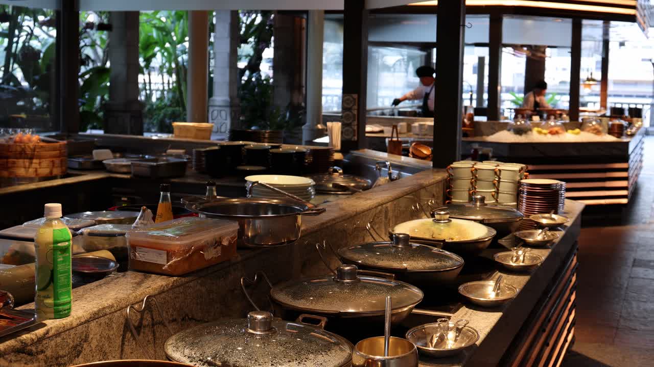 A close-up view of a buffet counter featuring neatly arranged plates and bowls in a modern setting.