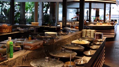 a close-up view of a buffet counter featuring neatly arranged plates and bowls in a modern setting.