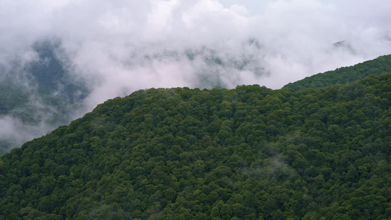 The mountains wear a cloak of fog in this aerial drone footage