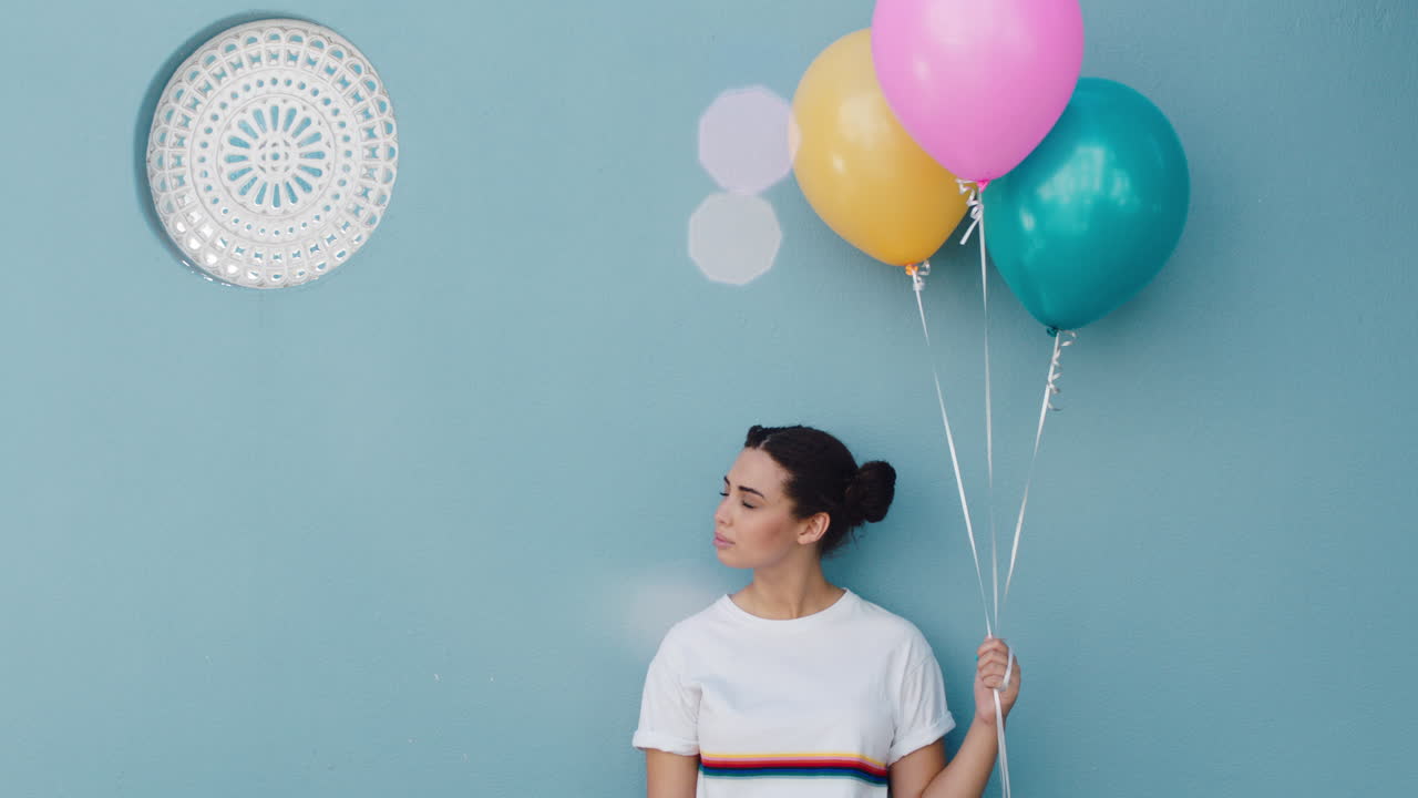 mujer feliz sosteniendo globos coloridos para la celebración de la fiesta de cumpleaños sonriendo juguetón disfrutando de la diversión 4k