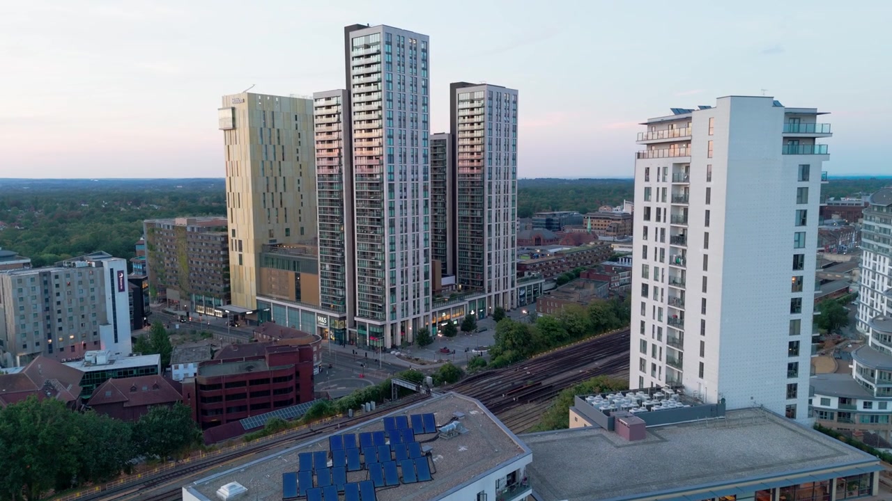 Pannelli solari sui tetti di moderni edifici residenziali, con grattacieli in un centro città rigenerato, carrellata aerea in avanti