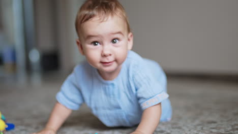 adorable cheerful laughing toddler standing on all fours on the floor and swaying. little kid playing with a toy.