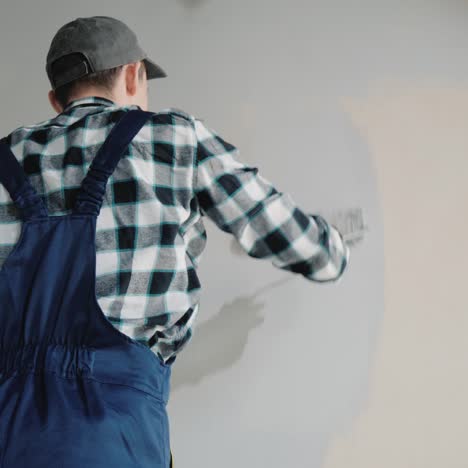 male builder paints wall with roller 3