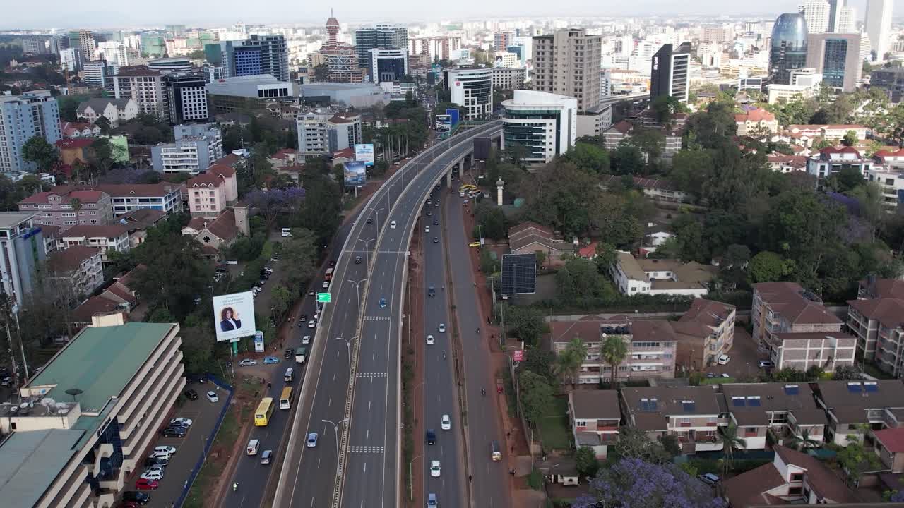A beautiful aerial drone footage of the city of Nairobi, Kenya, showcasing the bustling urban office spaces, modern residential areas, the Nairobi Expressway, and Waiyaki Way. Captured during the day