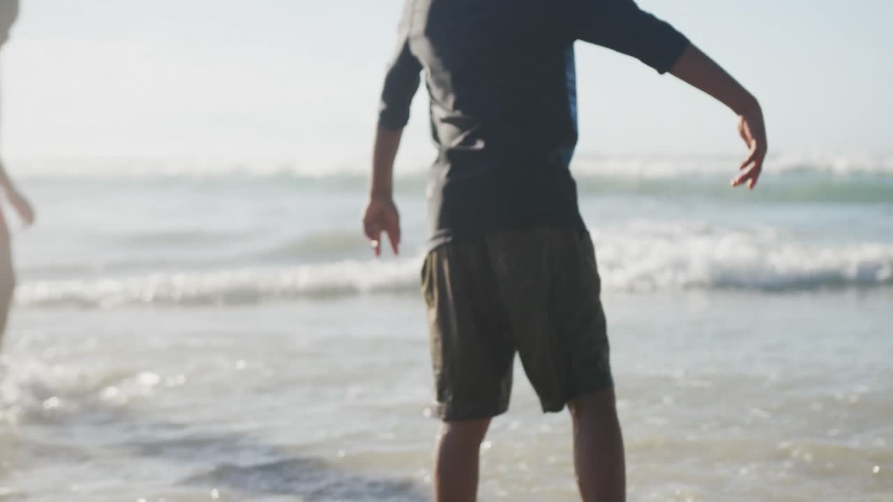 해변에서 즐기는 아프리카계 미국인 형제 자매의 뒷면