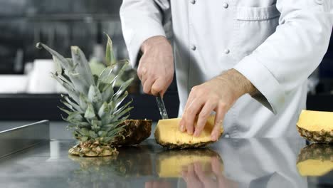 las manos del chef cortando la piña en cámara lenta. las manos del chef cortando fruta fresca