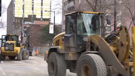 you can see two excavators working at the same time in a busy construction street.