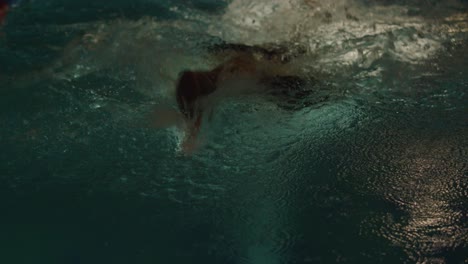 person swimming in a pool at night