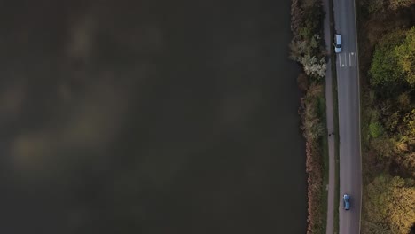 Scenic-lake-footpath-alongside-road-with-moving-cars